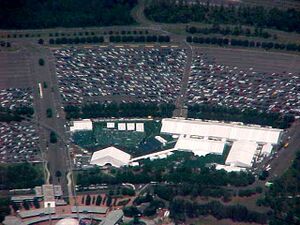 An overhead view of the main stage and stands outside the gates of EPCOT and the tents housing the pits and other playing fields deeper into the parking lot [8]