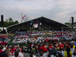 Dean Kamen speaking on the big stage with Spaceship Earth in the background[14]