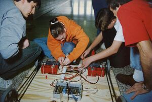 Team 45 wiring the 1997 control system, showing an RNet radio plugged into the receiver box, two drill battery holders, two drill motors, and two Tekin speed controllers. [9]
