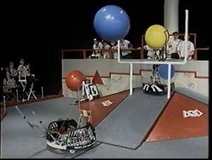 Team 141 launching a ball while 100 gets in position to score repeatedly [8]